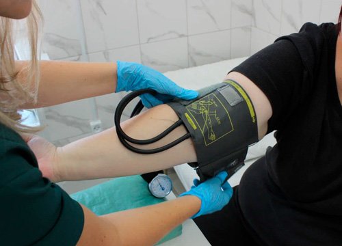 Врач измеряет давление пациенту